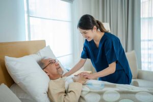 Older LGBTQ+ resident speaking with a caregiver in a bright assisted living common room.