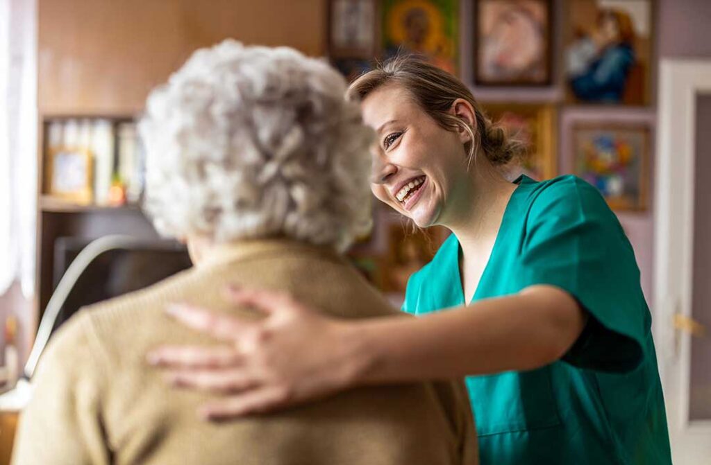 Older adult reviewing a care plan with a caregiver at a table beside a medication organizer.